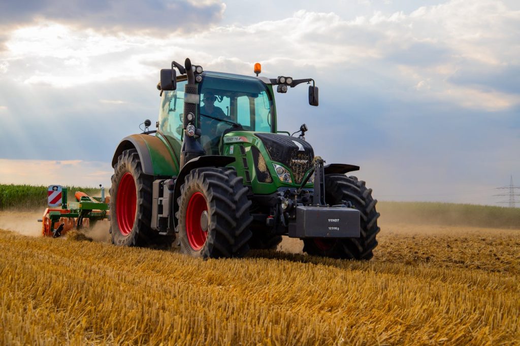 tractor ploughing old threshed wheat stalks back into the ground